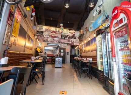 Salão com mesas e refrigeradores da The Burguest, Real Parque
